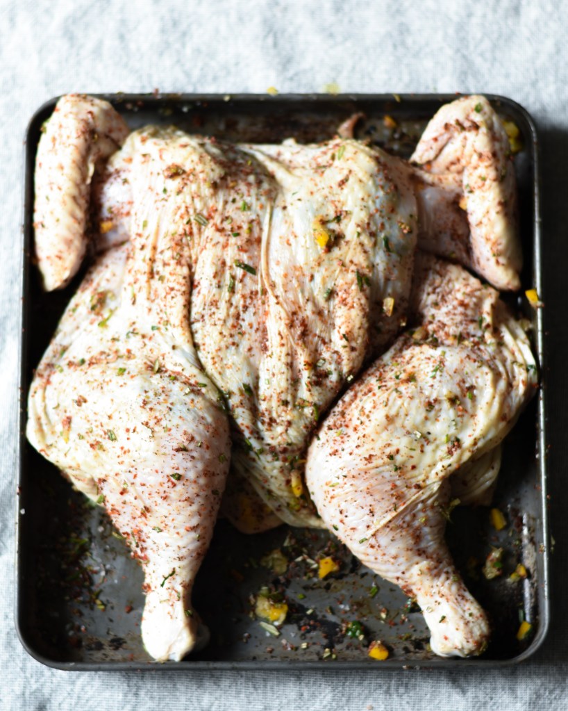 raw spatchcocked chicken with preserved lemon, sumac, herbs and Aleppo pepper