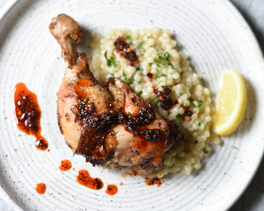 grilled chicken quarter leg and thigh over pearl couscous with crispy garlic chili oil